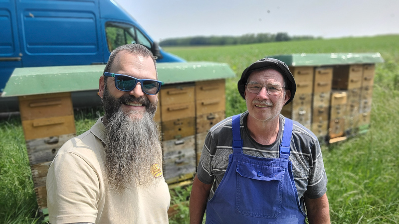 zwei Imker vor Bienenstöcken